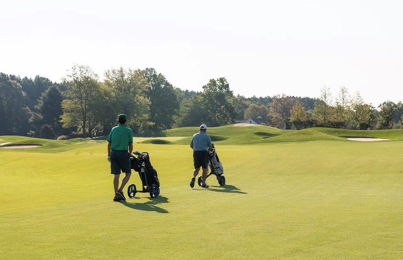 two golfers walking on fairway