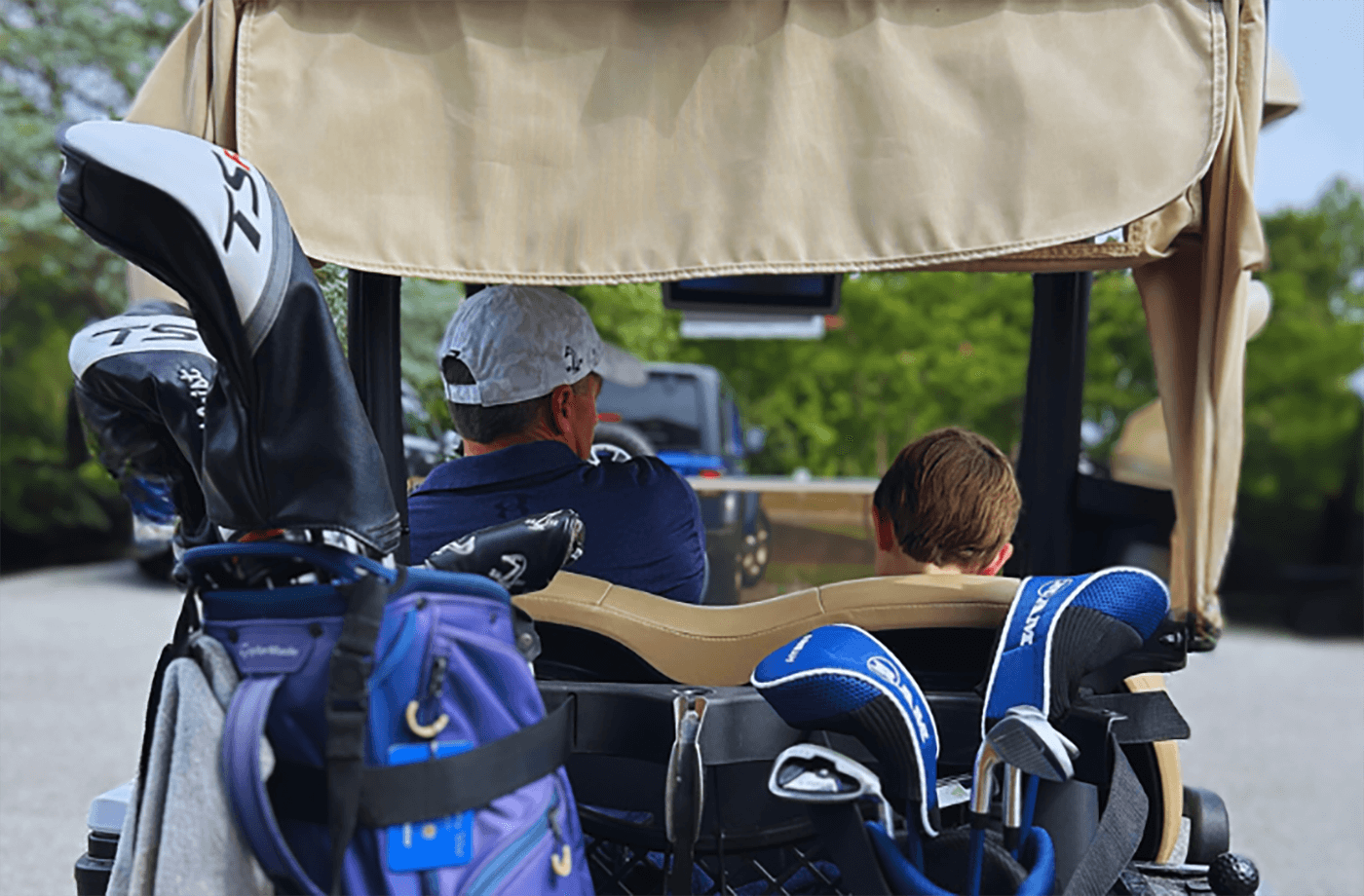 father and son in golf cart